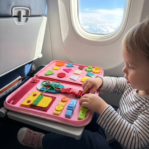 Enfant jouant avec le busy board Miloubo en avion